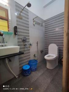 a bathroom with a white toilet and a sink at Hotel Prabhat in Varanasi