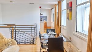 a dining room with a table and chairs and windows at The Monument in Newcastle upon Tyne