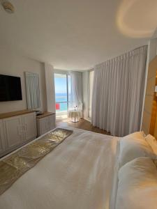 a bedroom with a large bed with a view of the ocean at King Solomon Hotel in Netanya