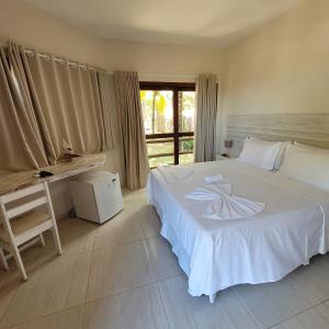 a bedroom with a bed and a desk and a window at RANCHO GOSTOSO POUSADA in São Miguel do Gostoso +21 photos