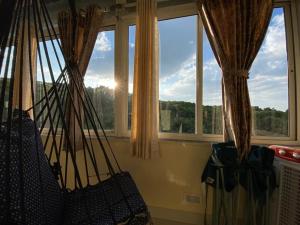 a room with windows with the sun shining through at Mayuri cottage in Mahabaleshwar