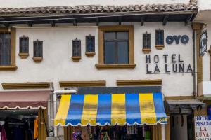 a building with a striped awning in front of a store at OYO Hotel La Luna in San Cristóbal de Las Casas
