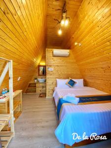 una camera con 2 letti in una cabina di legno di Homestay De la Rosa - Côn Đảo a Con Dao