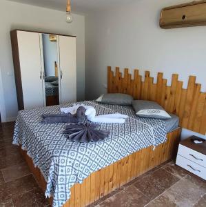 1 dormitorio con 1 cama grande y cabecero de madera en Asil Bungalows Orhaniye, en Orhaniye