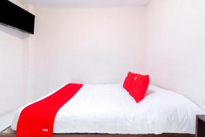 a bed with a red and white blanket on it at OYO Hotel La Luna in San Cristóbal de Las Casas