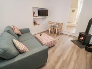 uma sala de estar com um sofá e um fogão a lenha em Tŷ Capel Bach em Bangor