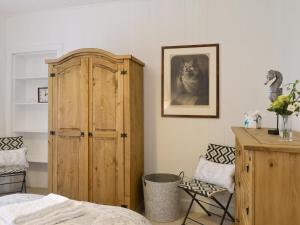 a bedroom with a wooden cabinet next to a bed at The Retreat in Belladrum