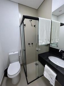 a bathroom with a shower and a toilet and a sink at NANO Suítes in Uberlândia