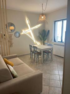 sala de estar con sofá y mesa con sillas en Casa Vacanze La Coccinella en Capo dʼOrlando