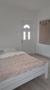 um quarto branco com uma cama e uma janela em Apartman Milena Temerin em Temerin
