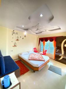 a bedroom with a bed and a blue couch at Mayuri cottage in Mahabaleshwar