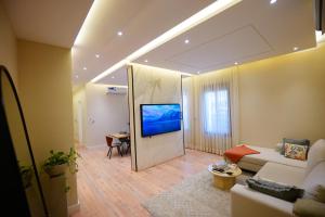 Spacious and Modern Apartment for Rent in Ergah, Riyadh في الرياض: غرفة معيشة مع أريكة وتلفزيون