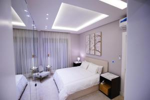 a bedroom with a large white bed and a chair at Spacious and Modern Apartment for Rent in Ergah, Riyadh in Riyadh