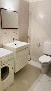 a bathroom with a sink and a washing machine at Condominio Fortino in Grado