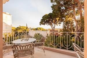 eine Terrasse mit einem Tisch und Stühlen auf dem Balkon in der Unterkunft Maison Carla Rosa Cannes in Cannes