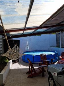 a hammock and chairs on a patio with a pool at Colinas in Ciudad de la Costa
