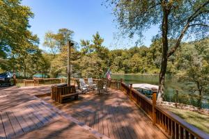 Heber SpringsRiverfront Retreat with Fire Pit Fish and Hike!的湖畔木甲板,带旗帜