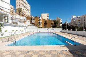 a swimming pool on the roof of a building at MalagaSuite Holidays Torremolinos in Torremolinos