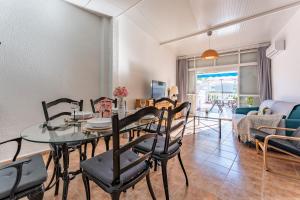 a dining room and living room with a table and chairs at MalagaSuite Holidays Torremolinos in Torremolinos