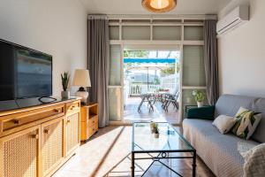 a living room with a couch and a flat screen tv at MalagaSuite Holidays Torremolinos in Torremolinos