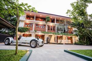 a white car parked in front of a building at River Inn - Fort in Matara