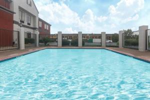 a swimming pool in front of a building at Super 8 by Wyndham Southaven in Southaven