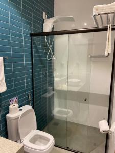 a bathroom with a toilet and a glass shower at POUSADA ESTÂNCIA in Penedo