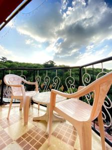 a balcony with two chairs and a bench on it at Mayuri cottage in Mahabaleshwar