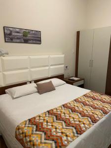 Un dormitorio con una cama con una manta de colores. en POUSADA ESTÂNCIA, en Penedo