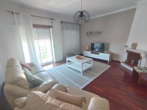 a living room with a couch and a table at Casa Flor de Mel in Sertã