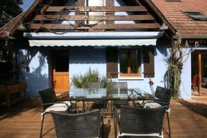 een eettafel en stoelen voor een huis bij Gîte La Réserve avec Jardin et Piscine in Ingersheim