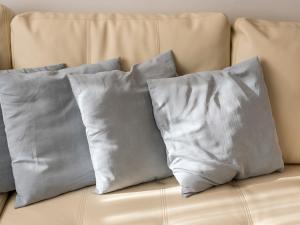 four pillows sitting on top of a couch at Pass the Keys Stylish 2 Bedroom Family Home in Worcester Park