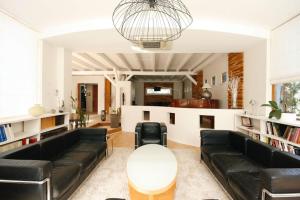 uma sala de estar com sofás de couro preto e uma mesa em Gîte La Réserve avec Jardin et Piscine em Ingersheim