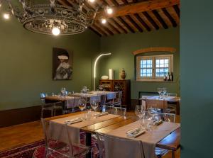 una sala da pranzo con tavoli e sedie e un lampadario di Agriturismo San Rocco a Pistoia