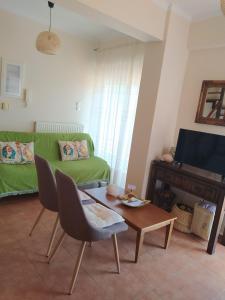 een woonkamer met een groene bank en een tafel bij Nafplio cozy maisonette in Nafplio