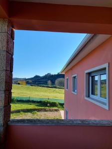 uma janela de uma casa cor-de-rosa com vista para um campo em Casa Susana em Sapataria