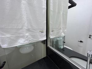 a bathroom with a shower and a toilet with a mirror at NANO Suítes - solteiro in Uberlândia +7 photos