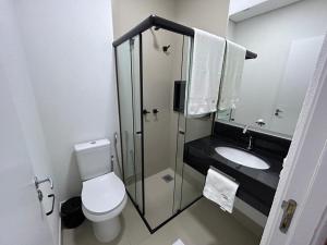 a small bathroom with a toilet and a sink at NANO Suítes in Uberlândia