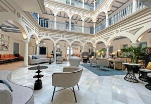 hol z krzesłami i stołami w budynku w obiekcie Itaca Sevilla by Soho Boutique w Sewilli