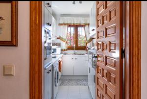 een keuken met witte apparatuur en een raam bij Andalusialaistyyppinen, 3 makuuhuoneen asunto Casa Zarina, Puebla Aida, Mijas in Santa Fe de los Boliches
