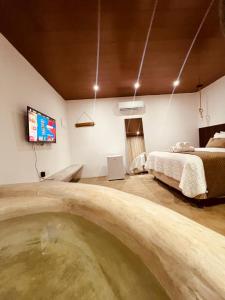um quarto com uma cama e uma televisão na parede em Refúgio da Rita em Fernando de Noronha