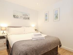 a bedroom with a bed with towels on it at Canny Cottage in Morpeth