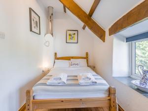 a bedroom with a bed with towels on it at Jarvies Cottage in Boscastle