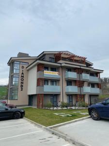 a building with cars parked in front of it at Apartmán Flower in Podhájska