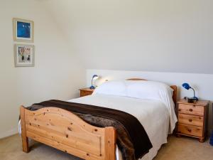 een slaapkamer met een houten bed en 2 nachtkastjes bij Prospecthill House in Whitehouse
