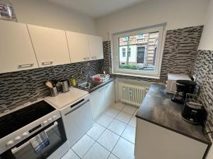 una cocina con armarios blancos y una ventana en Beautiful, large and great apartment with balcony in top location en Karlsruhe