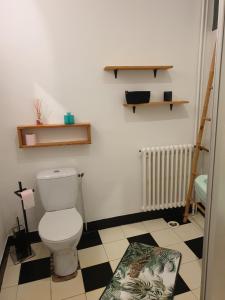 La salle de bains est pourvue de toilettes et d'un sol noir et blanc. dans l'établissement Lou-Pelou, à Gravières