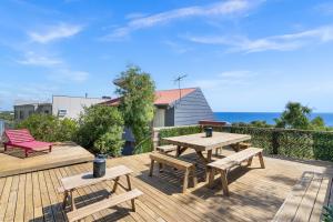 una terraza de madera con mesa de picnic y bancos en Oceanview Manor by "Peppy Beach Retreats" - Two Houses in One with Panoramic Views, en Capel