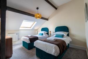 a bedroom with two beds with blue headboards at The Penthouse At Quayside in York