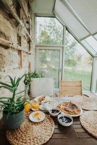 una mesa con desayuno y una ventana en Dagen Haus Guesthouse, en Orjaku